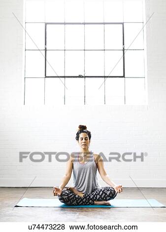 Woman meditating on exercise mat View Large Photo Image Stock Photo - Woman meditating on exercise mat. Fotosearch
