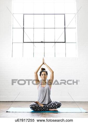 Stock Photography - Woman meditating on exercise mat. Fotosearch