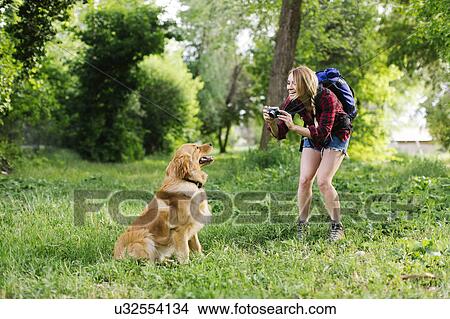 Woman photographing dog on hiking trip View Large Photo Image Picture - Woman photographing dog on hiking trip. Fotosearch