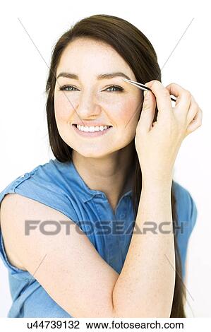 Stock Image - Woman plucking eyebrows. Fotosearch