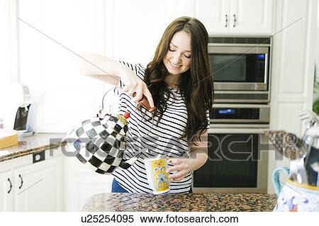 Woman pouring water from teapot View Large Photo Image Stock Photography - Woman pouring water from teapot. Fotosearch