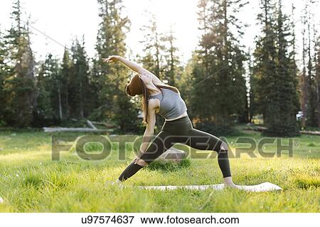 Stock Photo - Woman practicing yoga in forest. Fotosearch