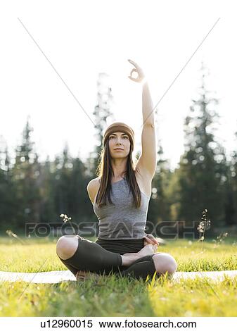 Stock Photography - Woman practicing yoga in forest. Fotosearch