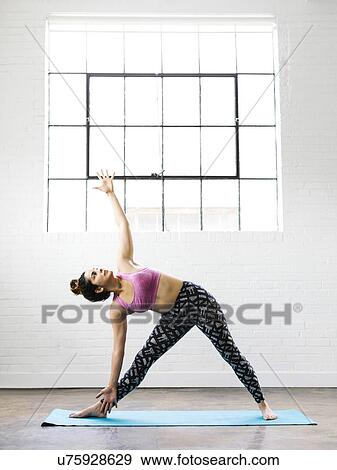 Woman practicing yoga on exercise mat View Large Photo Image Stock Photo - Woman practicing yoga on exercise mat. Fotosearch