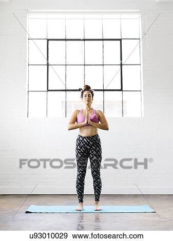 Stock Photo - Woman practicing yoga on exercise mat. Fotosearch