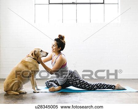 Stock Photography - Woman practicing yoga with dog. Fotosearch