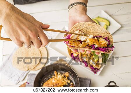 Woman preparing tortilla with tilapia and red cabbage View Large Photo Image Stock Image - Woman preparing tortilla with tilapia and red cabbage. Fotosearch
