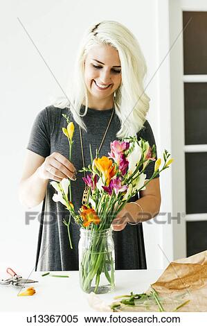Woman putting flowers into jar View Large Photo Image Stock Photography - Woman putting flowers into jar. Fotosearch