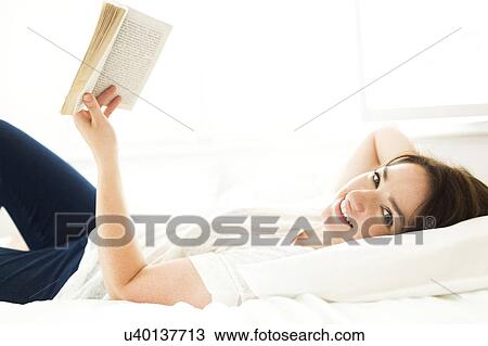 Woman reading book in bed View Large Photo Image Stock Image - Woman reading book in bed. Fotosearch