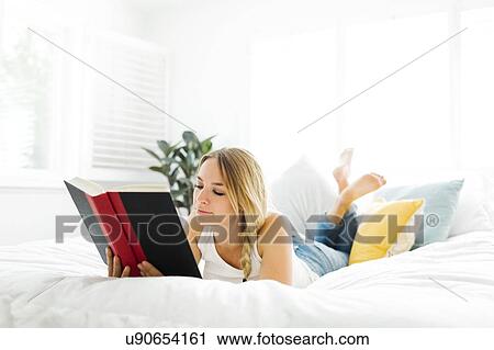 Woman reading book in bedroom View Large Photo Image Stock Image - Woman reading book in bedroom. Fotosearch