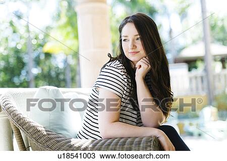 Stock Image - Woman resting on porch on sunny day. Fotosearch