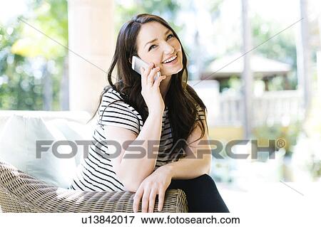 Stock Photo - Woman resting on porch on sunny day. Fotosearch