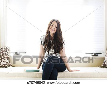 Woman sitting on couch View Large Photo Image Stock Image - Woman sitting on couch. Fotosearch