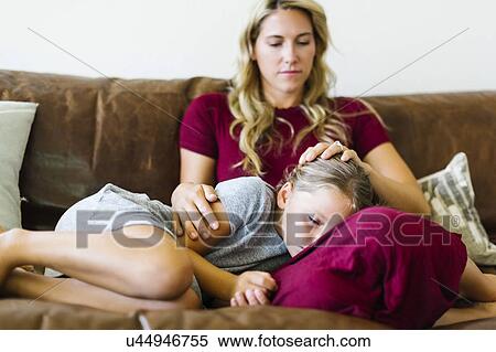 Woman sitting with daughter (6-7) on couch View Large Photo Image Stock Photography - Woman sitting with daughter (6-7) on couch. Fotosearch