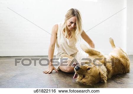 Stock Photograph - Woman stroking dog. Fotosearch
