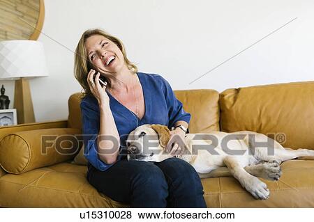 Woman stroking Labrador Retriever and using mobile phone View Large Photo Image Stock Photo - Woman stroking Labrador Retriever and using mobile phone. Fotosearch