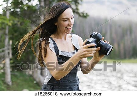 Woman taking pictures by lake View Large Photo Image Stock Photo - Woman taking pictures by lake. Fotosearch