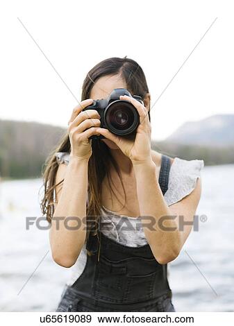 Woman taking pictures by lake View Large Photo Image Stock Photo - Woman taking pictures by lake. Fotosearch
