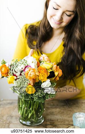 Stock Photography - Woman touching bouquet of ranunculus. Fotosearch