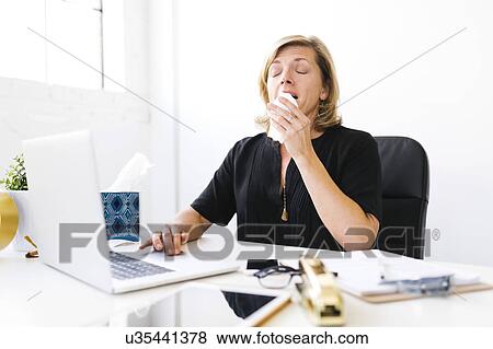 Woman using laptop and sneezing View Large Photo Image Stock Photo - Woman using laptop and sneezing. Fotosearch