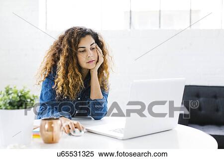 Woman using laptop at table View Large Photo Image Stock Photography - Woman using laptop at table. Fotosearch