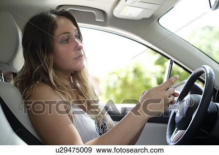 Woman using smartphone in car View Large Photo Image Stock Photo - Woman using smartphone in car. Fotosearch