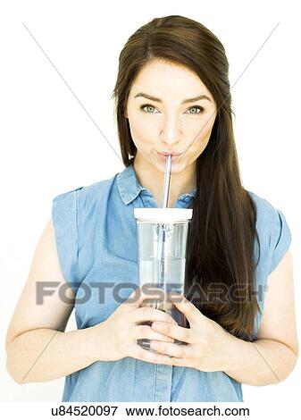 Woman wearing blue top drinking water from drinking glass View Large Photo Image Stock Photo - Woman wearing blue top drinking water from drinking glass. Fotosearch