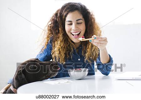 Woman with dog eating snack View Large Photo Image Stock Photo - Woman with dog eating snack. Fotosearch