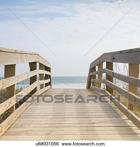 Stock Photograph - Wooden boardwalk by sea. Fotosearch