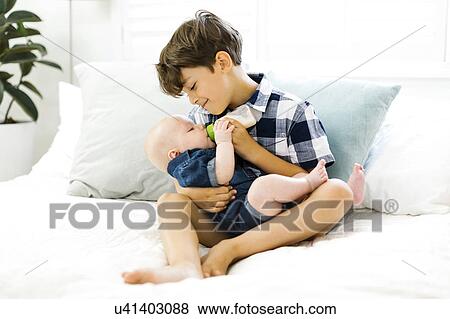 Young boy (6-7) feeding brother (2-5 months) View Large Photo Image Stock Photo - Young boy (6-7) feeding brother (2-5 months). Fotosearch