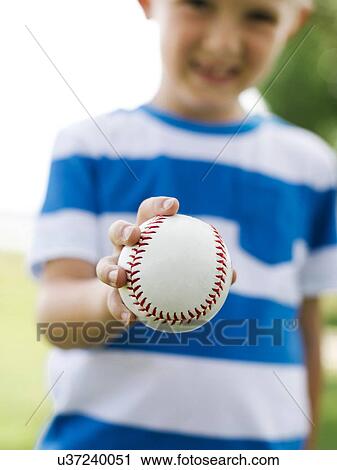 Young boy (6-7) holding baseball ball View Large Photo Image Stock Image - Young boy (6-7) holding baseball ball. Fotosearch