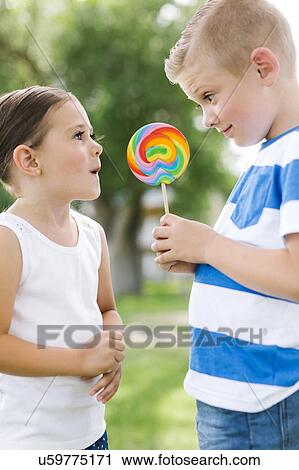 Young boy (6-7) showing sister (4-5) lollipop View Large Photo Image Stock Image - Young boy (6-7) showing sister (4-5) lollipop. Fotosearch