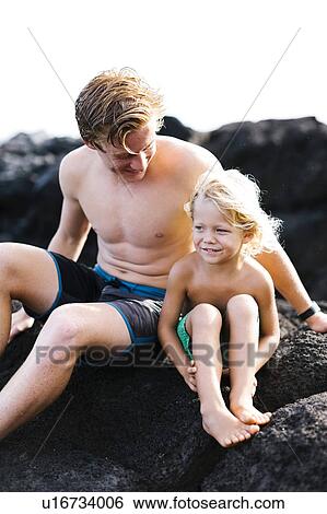 Young man with younger brother (4-5) sitting on rocks View Large Photo Image Stock Photograph - Young man with younger brother (4-5) sitting on rocks. Fotosearch