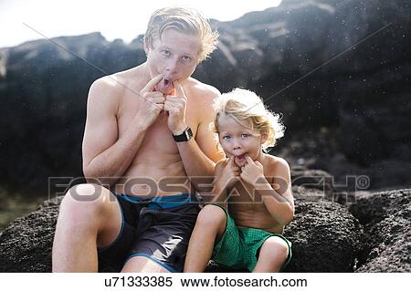 Young man with younger brother (4-5) sitting on rocks View Large Photo Image Stock Photography - Young man with younger brother (4-5) sitting on rocks. Fotosearch