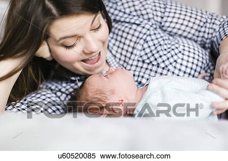 Young mother with baby girl (0-1 months) lying on bed View Large Photo Image Stock Photography - Young mother with baby girl (0-1 months) lying on bed. Fotosearch