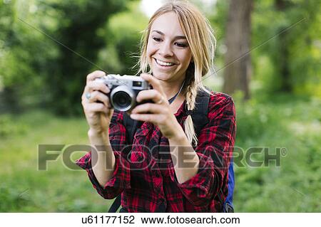 Young woman taking pictures in park View Large Photo Image Stock Image - Young woman taking pictures in park. Fotosearch