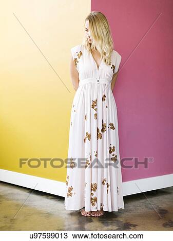 Young woman wearing long dress standing on corner View Large Photo Image Stock Image - Young woman wearing long dress standing on corner. Fotosearch