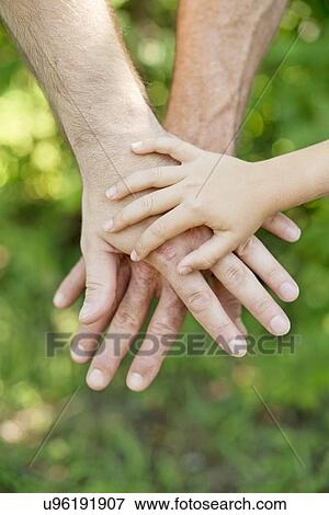 Stock Photo - Adult and child's hands on top of each other.. Fotosearch