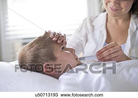 Boy having his temperature taken. View Large Photo Image Stock Image - Boy having his temperature taken.. Fotosearch