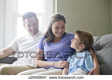 Boy sitting on sofa with his mother and father, portrait. View Large Photo Image Stock Image - Boy sitting on sofa with his mother and father, portrait.. Fotosearch