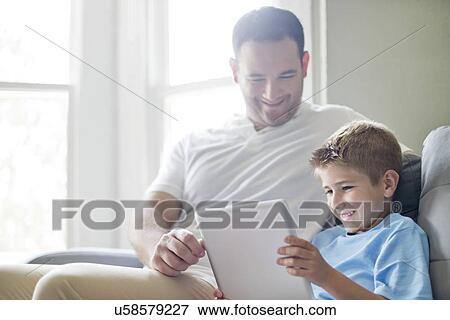 Boy using digital tablet with his father. View Large Photo Image Stock Photo - Boy using digital tablet with his father.. Fotosearch