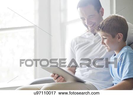 Stock Photo - Boy using digital tablet with his father.. Fotosearch