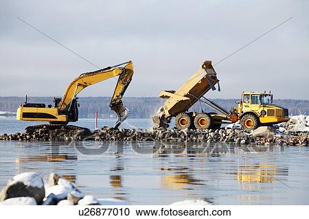 Stock Image - Bulldozer excavating along coast.. Fotosearch