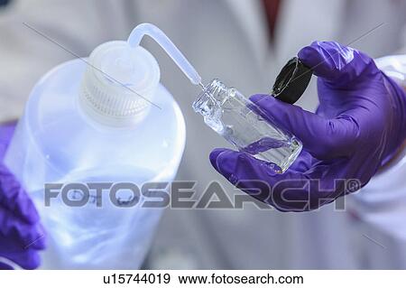Chemist adding distilled water to sample. View Large Photo Image Stock Photo - Chemist adding distilled water to sample.. Fotosearch