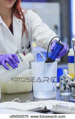 Stock Photo - Chemist adding distilled water while measuring pH.. Fotosearch