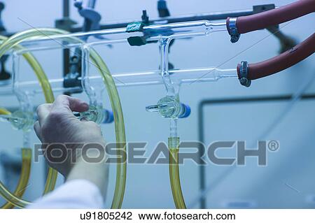 Chemist adjusting a tap on a burette in a pharmaceutical laboratory. View Large Photo Image Stock Image - Chemist adjusting a tap on a burette in a pharmaceutical laboratory.. Fotosearch
