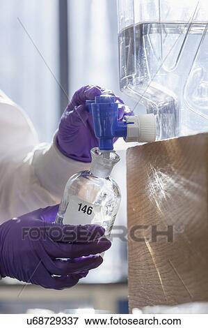 Stock Photo - Chemist collecting reagent.. Fotosearch