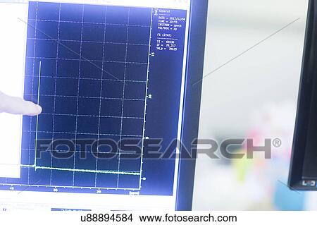 Chemist looking at NMR (nuclear magnetic resonance) spectroscopy results on a screen in a pharmaceutical laboratory. View Large Photo Image Picture - Chemist looking at NMR (nuclear magnetic resonance) spectroscopy results on a screen in a pharmaceutical laboratory.. Fotosearch