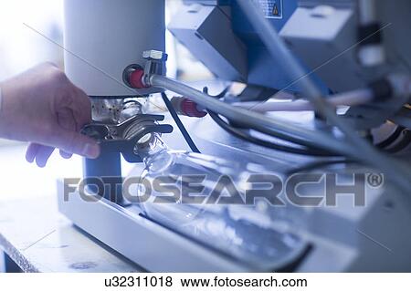 Stock Photo - Chemist setting up a vacuum pump in a pharmaceutical laboratory.. Fotosearch