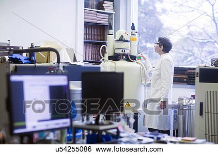 Chemist using an NMR (nuclear magnetic resonance) spectrometer in a pharmaceutical laboratory. View Large Photo Image Stock Photograph - Chemist using an NMR (nuclear magnetic resonance) spectrometer in a pharmaceutical laboratory.. Fotosearch